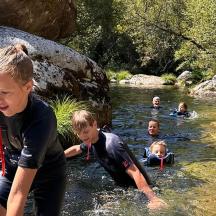 a group of children swimming in a river