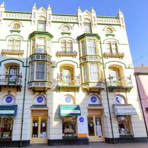 a large white building with balconies on a street