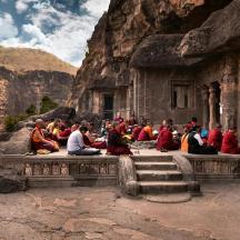 a group of people sitting on a ledge in a mountain