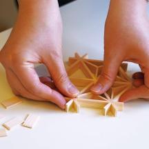 a person playing with wooden dominoes on a table