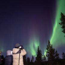 a group of people taking a picture of the northern lights