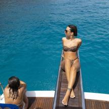eine Frau im Bikini sitzt auf einem Boot im Wasser