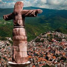Una estatua de Cristo Redentor en la cima de una ciudad.