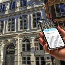 eine Person, die ein Mobiltelefon vor einem Gebäude hält