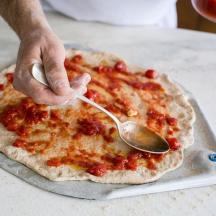 en person spiser pizza med en skje