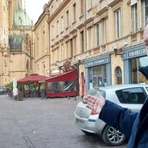 a man standing next to a car on a street