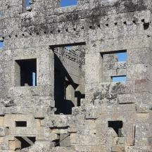 an old stone building with windows on top of it