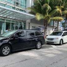 zwei Autos parkten vor einem Gebäude mit Palmen