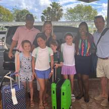 a family posing for a picture with their luggage