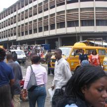 a group of people walking around a busy city street