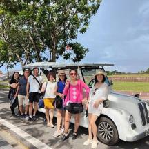 a group of people standing in front of a small car