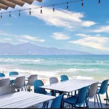 a group of tables and chairs on the beach
