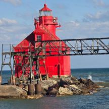 ein roter Leuchtturm auf einem Felsen im Meer