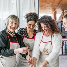 một nhóm phụ nữ đứng cùng nhau trong bếp