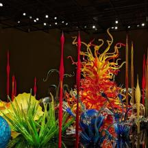a display of colorful glass vases and red candles