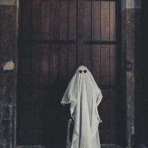 una persona disfressada de fantasma davant d'una porta