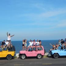 a group of people sitting on top of their cars