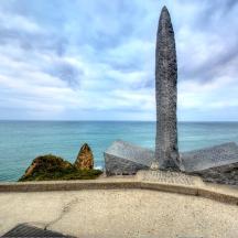 a statue on top of a wall near the ocean