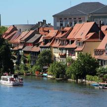 ein Boot auf einem Fluss mit Häusern und Gebäuden