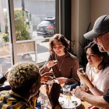 a group of people sitting around a table looking at their cell phones