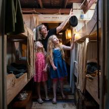 una dona i dues nenes petites dempeus en una habitació