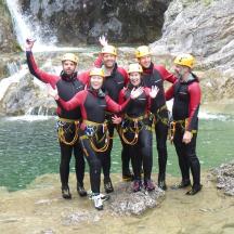 eine Gruppe von Menschen steht vor einem Wasserfall