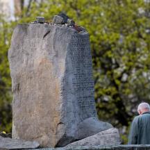 a man is standing next to a stone monument