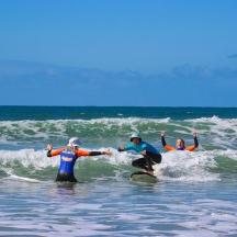three people in the ocean on surfboards in the water