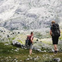 due persone con zaini che camminano su una montagna
