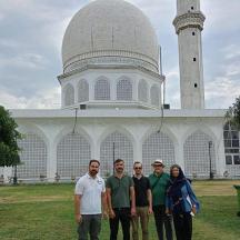 eine Gruppe von Menschen steht vor einer Moschee