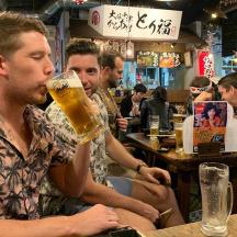 a group of men sitting at a bar drinking beer