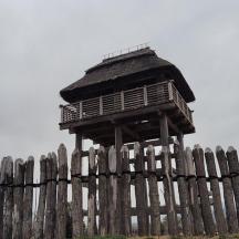 a wooden fence with a building on top of it