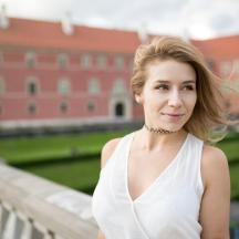 a woman in a white dress standing on a bridge
