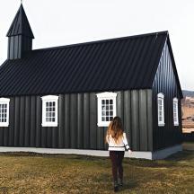 a woman standing in front of a black church