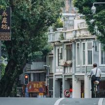 a man riding a bike down a city street