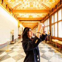 a woman taking a picture of statues in a museum