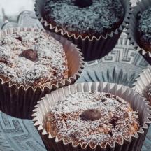 Un montón de pastelitos de chocolate con azúcar en polvo encima.