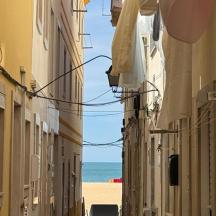 an empty street with the ocean in the background