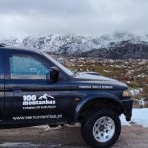 a black truck parked in front of a snow covered mountain
