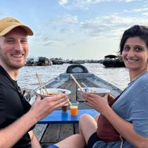 a man and a woman sitting at a table on a boat