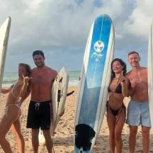 a group of people standing on the beach with surfboards
