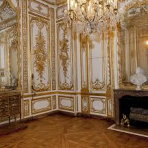 an ornate room with a fireplace and a chandelier