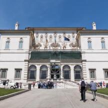 people walking in front of a large white building