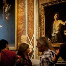a group of people looking at a painting in a museum