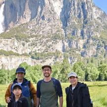 a group of people standing in front of a mountain