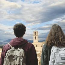 ein Mann und eine Frau mit Rucksäcken schauen sich ein Schloss an