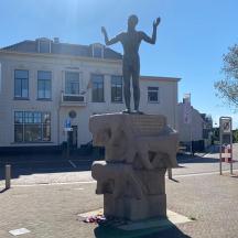 a statue of a woman on a fountain in front of a building
