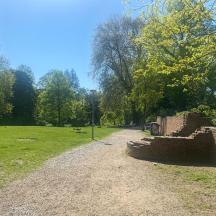 una strada sterrata in un parco con un muro di mattoni