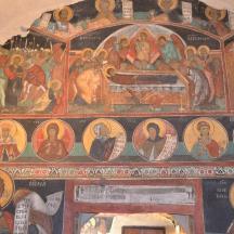 a room with a wall filled with religious paintings