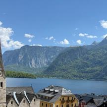 a church next to a lake with mountains in the background